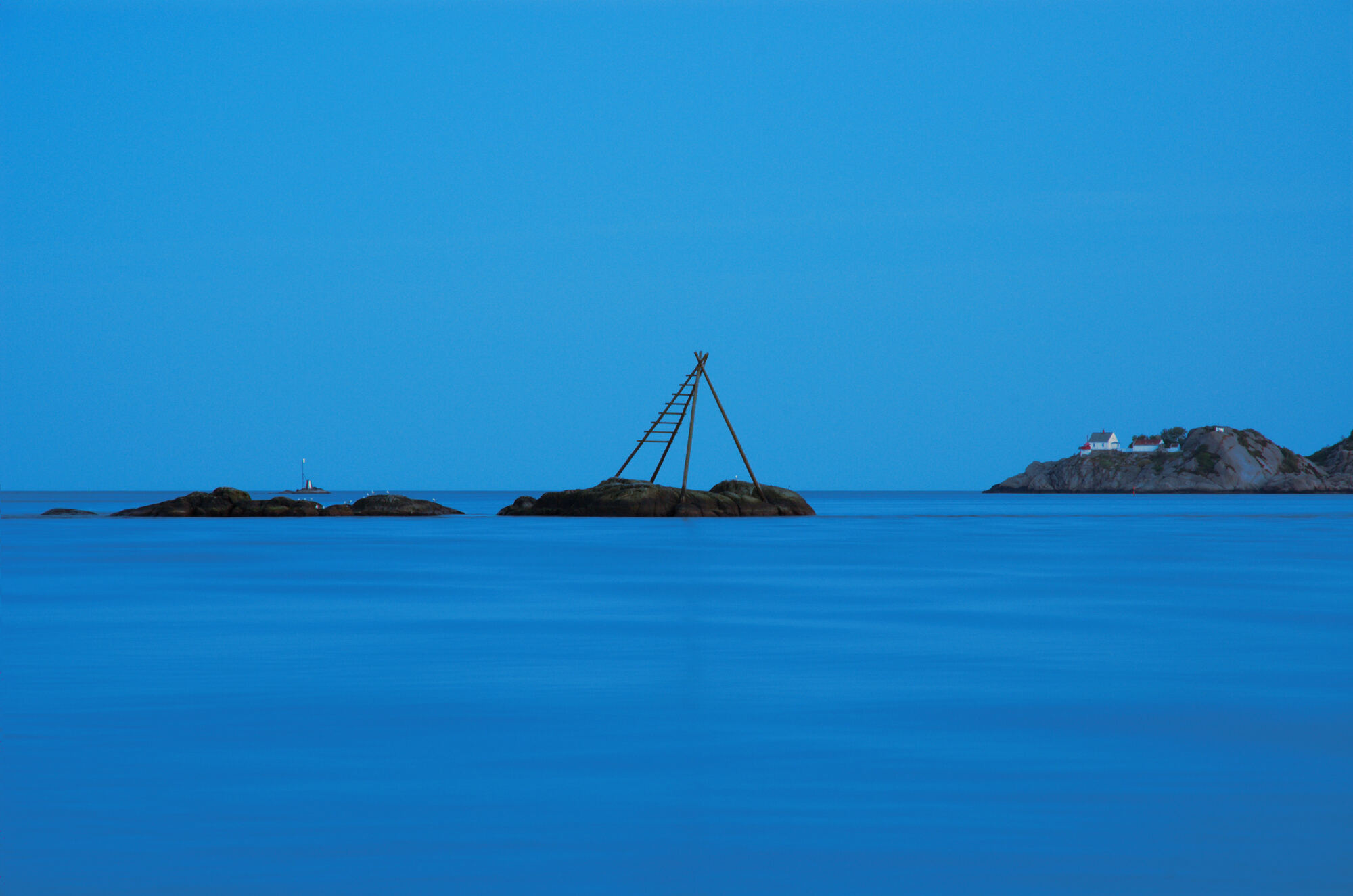 Sea mark and islets in blue evening light outside Mandal